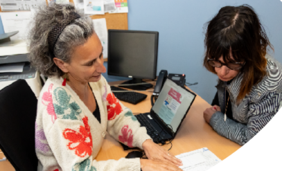Une conseillère de la MDPH accompagne une personne devant un ordinateur.